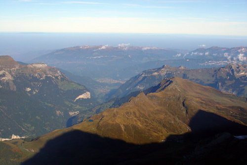  Mönch a Eiger vrhajú ranné tiene na Lauberhorn (je vidieť prestupnú stanicu Kleine Scheidegg), hlboko v doline vidno Interlaken